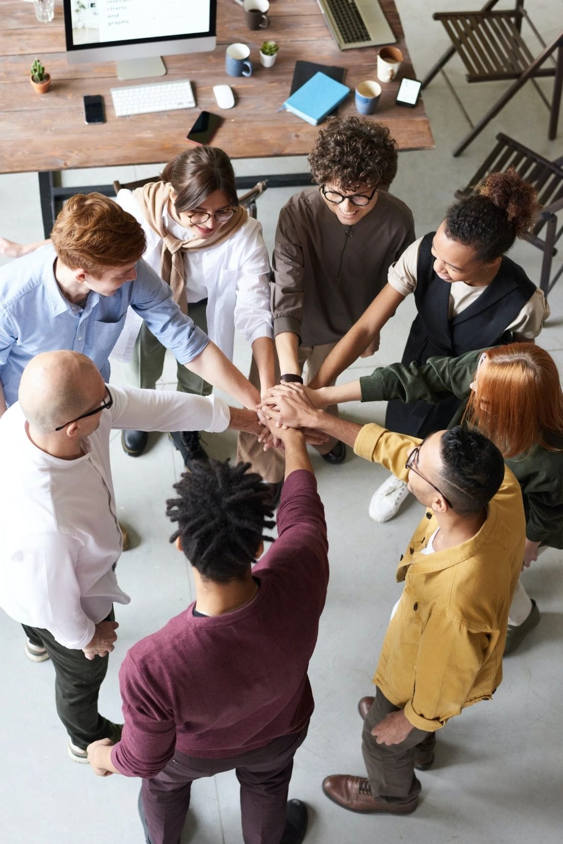A team stacking their hands together in the middle of a circle